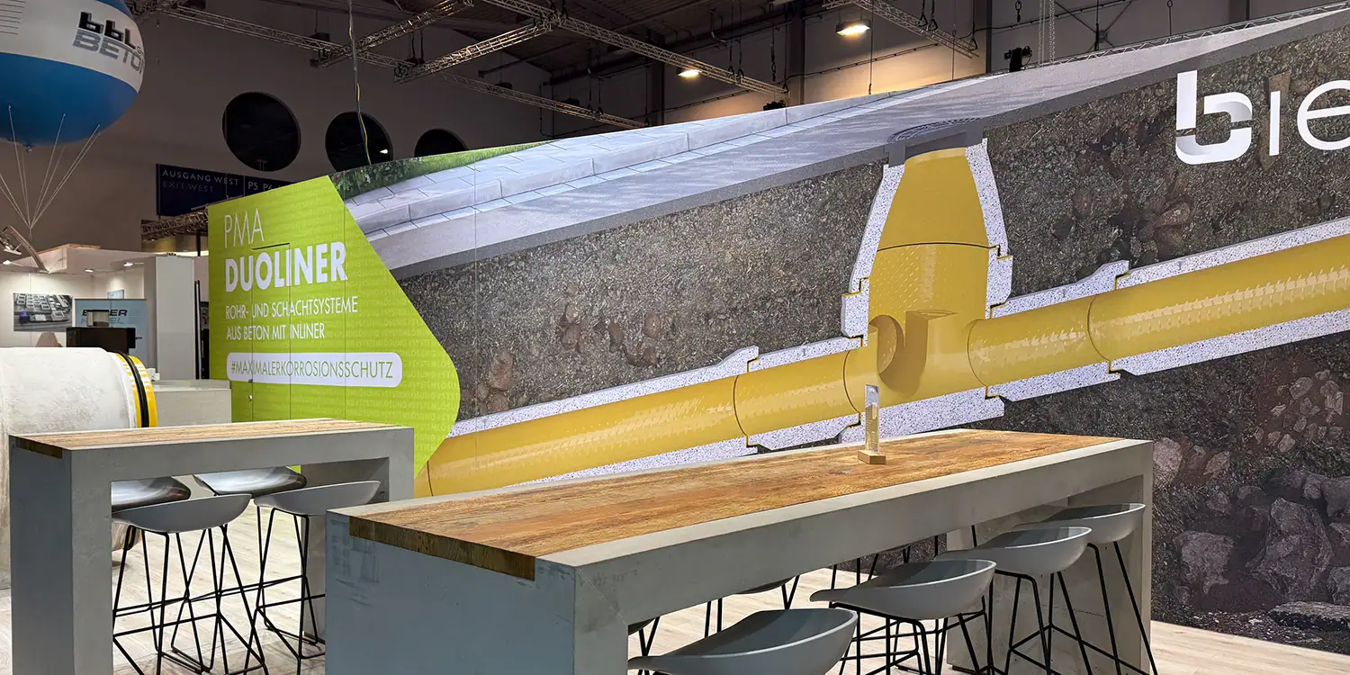 Messestand des Betonwerks Bieren mit einer Schnittdarstellung eines Rohrsystems im Erdreich